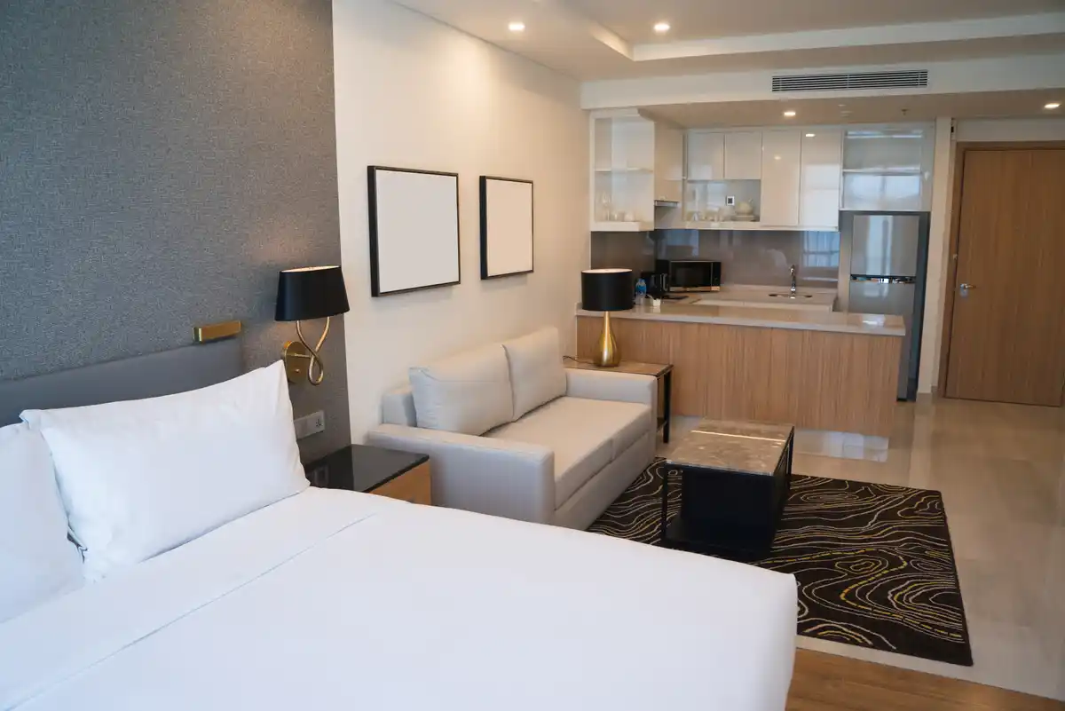 Service Apartment in Pune with all-inclusive amenities: RoomerStays studio with queen bed, equipped kitchenette, daily housekeeping, and professional coliving services near Amanora and Seasons Mall.